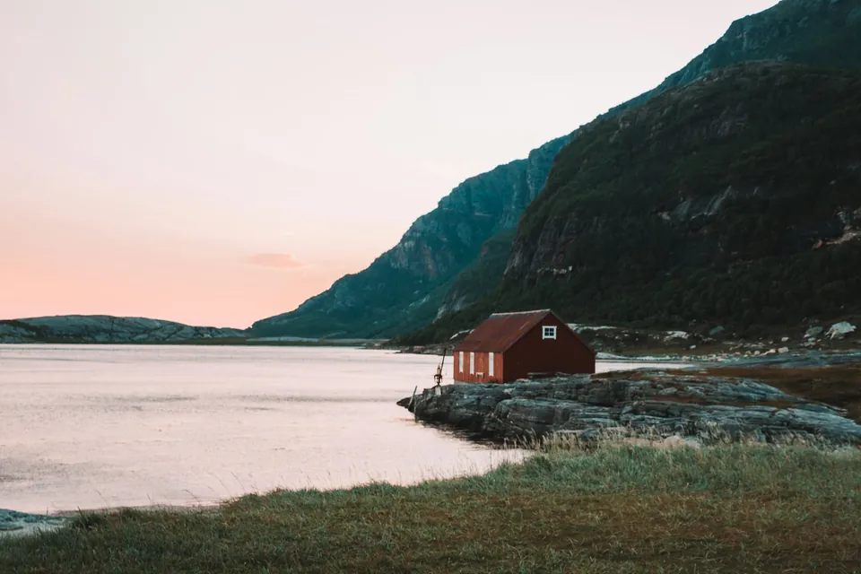 A peaceful waterfront scene in near Bodø, Norway, with a small fisherman’s hut on the water’s edge