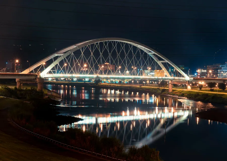The Walterdale Bridge at night casting reflections on the North Saskatchewan River