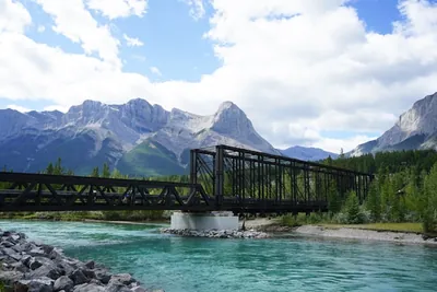 Black bridge over blue river in a mountainous landscape near Canmore, Canada